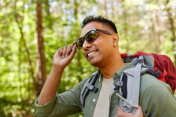 Image showing happy indian man with backpack hiking in forest