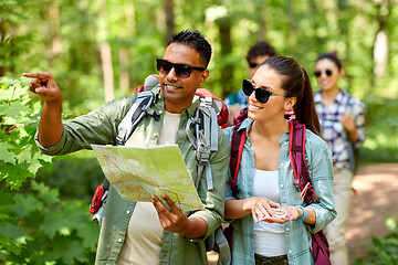 Image showing friends with map and backpacks hiking in forest