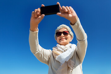 Image showing senior woman taking selfie by smartphone outdoors