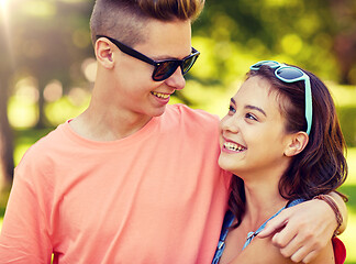 Image showing happy teenage couple looking at each other in park