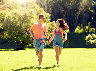 Image showing happy teenage couple running at summer park