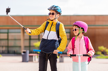 Image showing happy school kids with scooters taking selfie