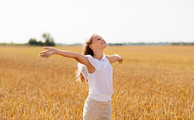 Image showing smiling young girl on cereal field in summer