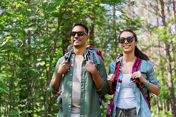 Image showing mixed race couple with backpacks hiking in forest