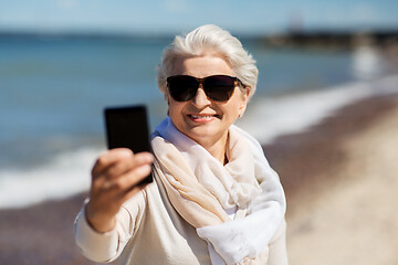 Image showing senior woman taking selfie by smartphone on beach