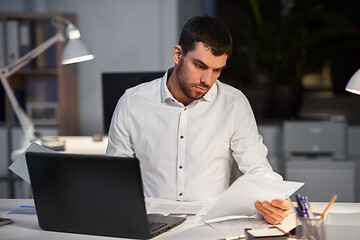 Image showing businessman with papers working at night office