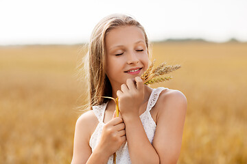 Image showing girl with spikelet of wheat on cereal field