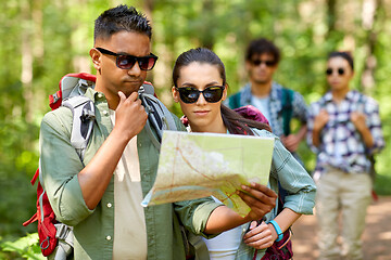 Image showing friends with map and backpacks hiking in forest