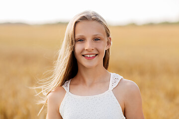 Image showing smiling young girl on cereal field in summer