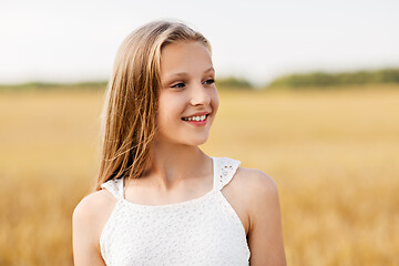 Image showing smiling young girl on cereal field in summer