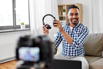 Image showing male blogger with headphones videoblogging at home