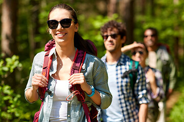 Image showing group of friends with backpacks hiking in forest