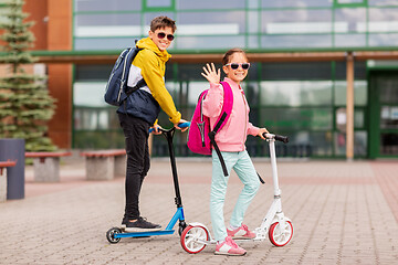 Image showing school children with backpacks riding scooters