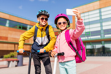 Image showing happy school kids with scooters taking selfie