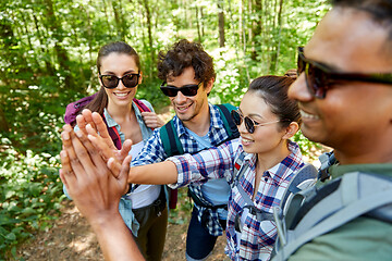 Image showing friends with backpacks hiking and making high five
