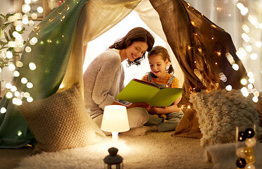 Image showing happy family reading book in kids tent at home