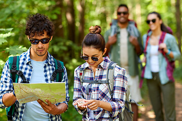 Image showing friends with map and backpacks hiking in forest