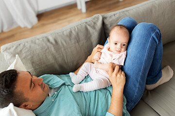 Image showing middle aged father with baby lying on sofa at home