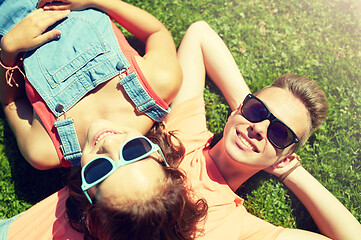 Image showing happy teenage couple lying on grass at summer