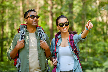 Image showing mixed race couple with backpacks hiking in forest