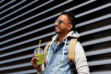 Image showing man with backpack drinking smoothie on street