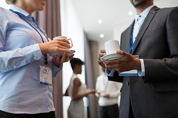 Image showing business people with conference badges and coffee