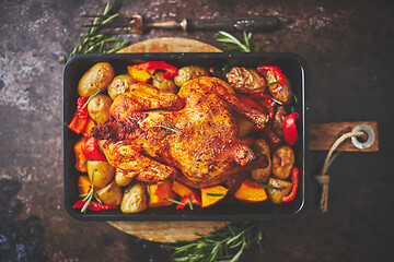 Image showing Delicious whole chicken cooked with pumpkin, pepper and potatoes. Served in metal baking pan.