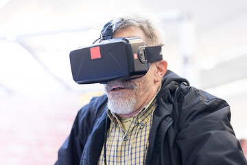 Image showing Senior man wearing virtual reality headset glasses. Virtual reality presentation