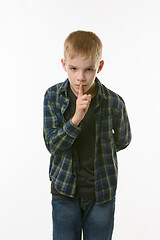 Image showing Portrait of teenager boy showing quieter sign, pressing index finger to his mouth