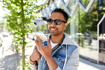 Image showing man recorving voice message on smartphone in city