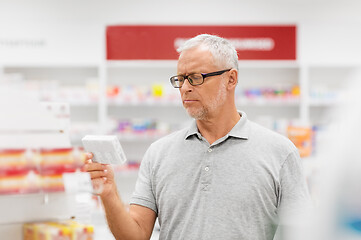 Image showing senior male customer with drug at pharmacy