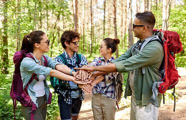 Image showing friends with backpacks stacking hands in forest