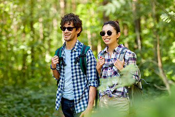 Image showing mixed race couple with backpacks hiking in forest