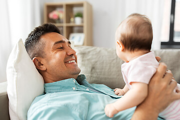 Image showing middle aged father with baby lying on sofa at home