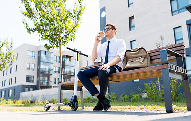 Image showing businessman with scooter drinking coffee in city