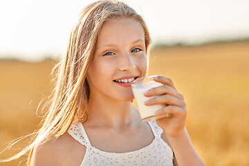 Image showing girl drinking milk from glass on cereal field