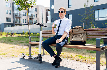 Image showing businessman with scooter drinking smoothie in city