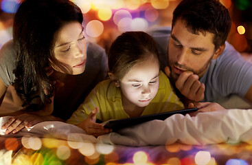 Image showing family with tablet pc in bed at night at home