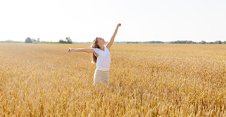 Image showing happy smiling young girl on cereal field in summer