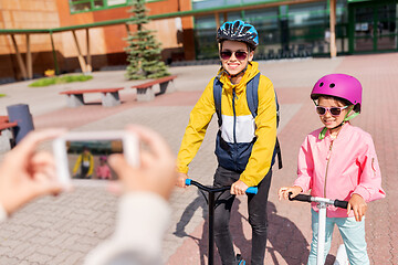 Image showing school kids with scooters photographing by cell