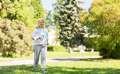 Image showing senior woman running along summer park