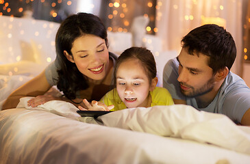 Image showing family with tablet pc in bed at night at home