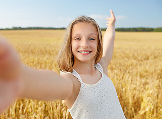 Image showing happy girl taking selfie on cereal field