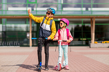 Image showing happy school kids with scooters taking selfie