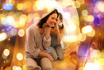 Image showing happy family whispering in kids tent at home