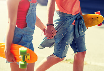 Image showing close up of young couple with skateboards in city