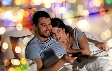 Image showing happy couple watching tv in bed at night at home