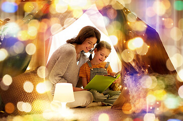 Image showing happy family reading book in kids tent at home