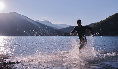 Image showing triathlon athlete starting swimming training on lake