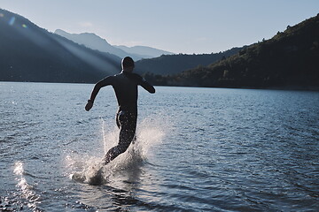 Image showing triathlon athlete starting swimming training on lake